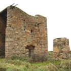 A large stone building and outhouse