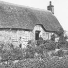 Black and white photo of a thatched cottage