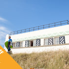 A white building with a surfer