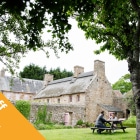 a stone building with people at picnic bench