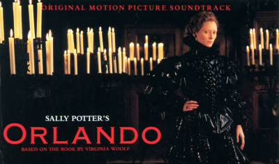 Person stands in black costume in front of candlesticks