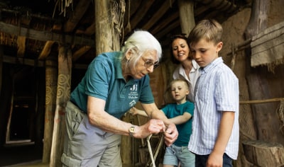 Person shows a young boy how to tie a knot