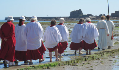 A group of people take a Pilgrimage across a causeway