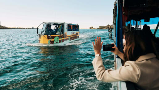 Elizabeth Castle person leans out of ferry to wave at passing ferry