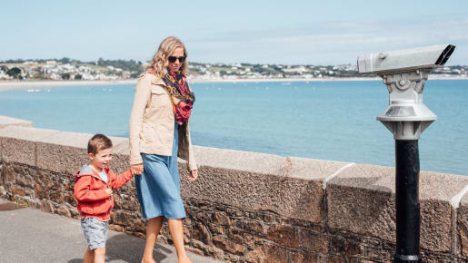 Mother and sun walk along the Promenade with sea in the background