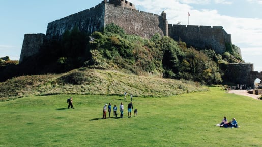 Large green space called The Castle Green with Mont Orgueil Castle in the background