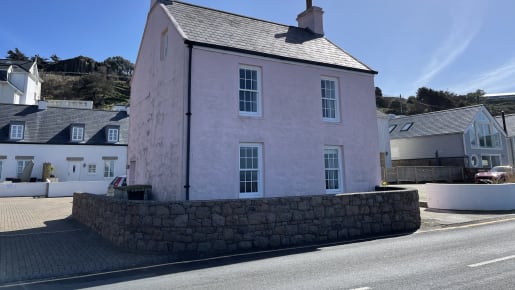 A small pink cottage with four windows