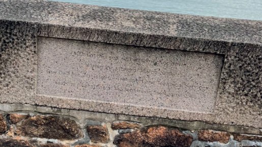 A memorial stone set into a sea wall