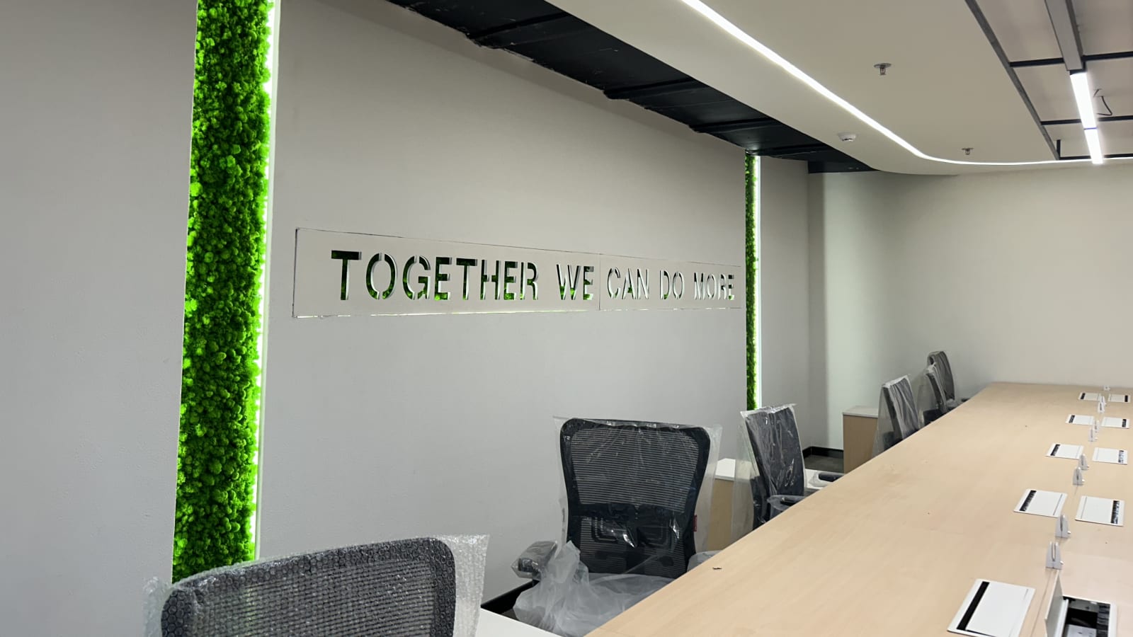 Meeting room ceiling with linear lighting, smoke detector and services coordinated into the false ceiling in an Officea fit-out