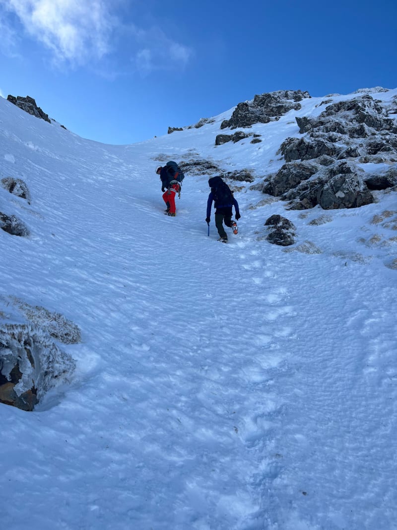 Kicking steps up a steep snow section on the east ridge