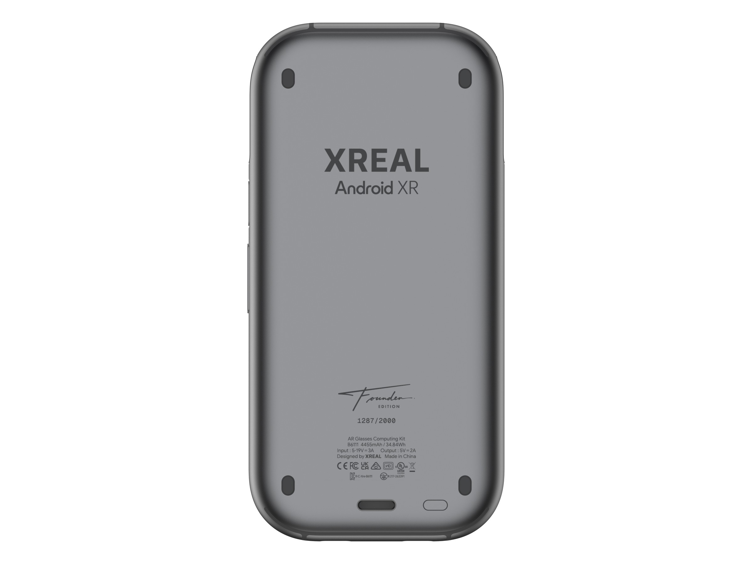 The back of the grey XREAL AURA Founder Edition compute puck, showing the XREAL and Android XR logos, a Founder Edition signature, the number 1287/2000 and small print listing a 4455mAh, 34.84Wh battery