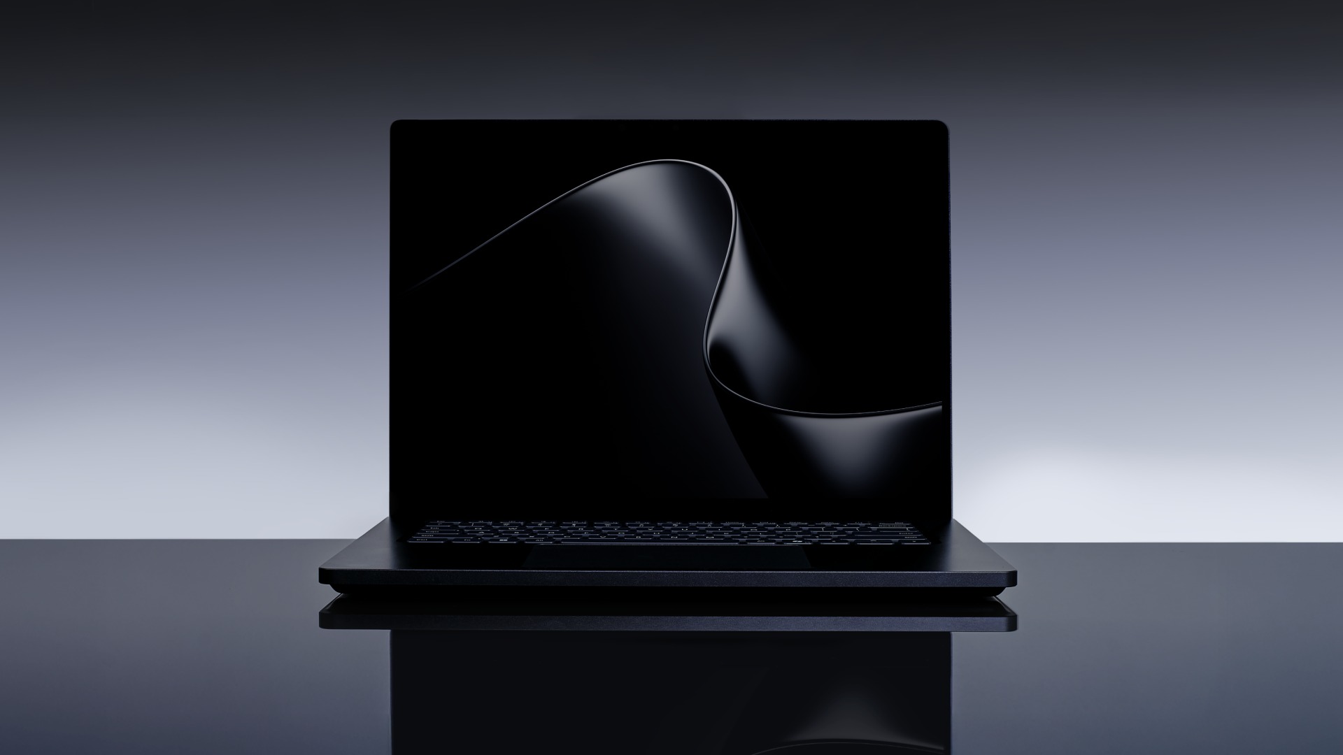 Surface Laptop Ultra open and facing the camera, a black wave wallpaper on its 15-inch screen, reflected in a dark glossy table against a grey gradient background