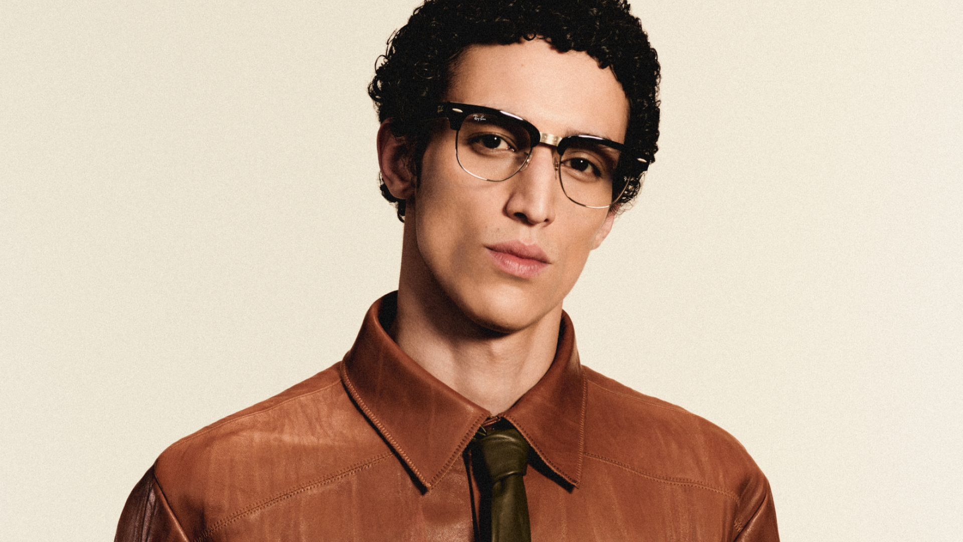 Official Meta studio portrait of a man wearing Ray-Ban Meta Audio Clubmaster browline glasses with clear lenses against a plain light background