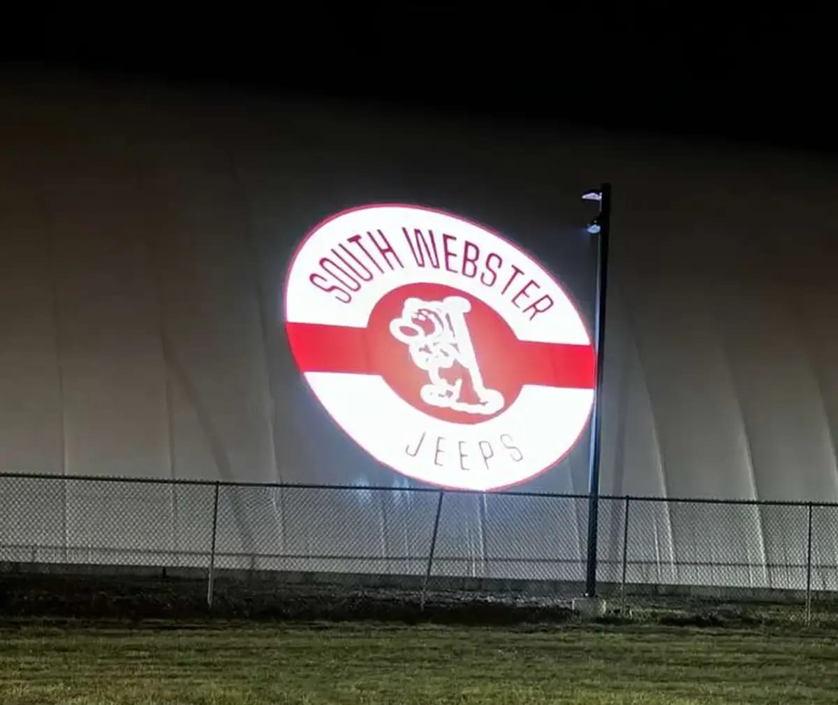School spirit crest projected at giant scale on an inflatable sports dome at night — Infinity Projectors