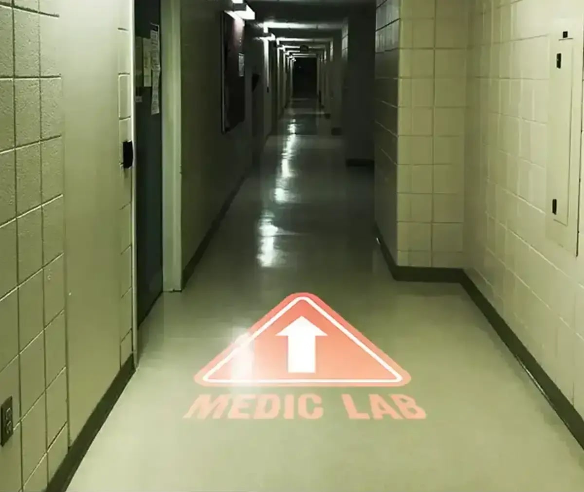Wayfinding arrow projected on a clinic corridor floor, guiding visitors after dark — Infinity Projectors