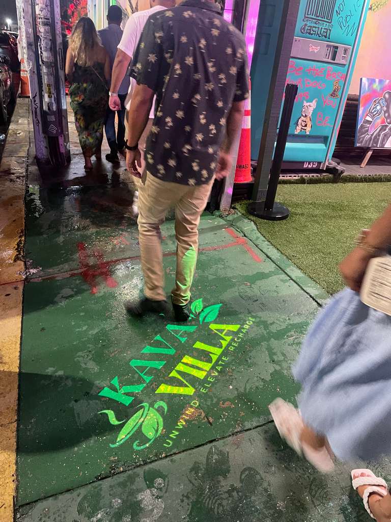 Logo projected on a storefront at night — Infinity Projectors
