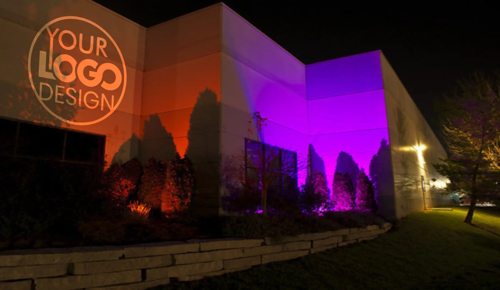 Placeholder logo shown on a warehouse wall washed in orange and purple to preview an outdoor logo projector display