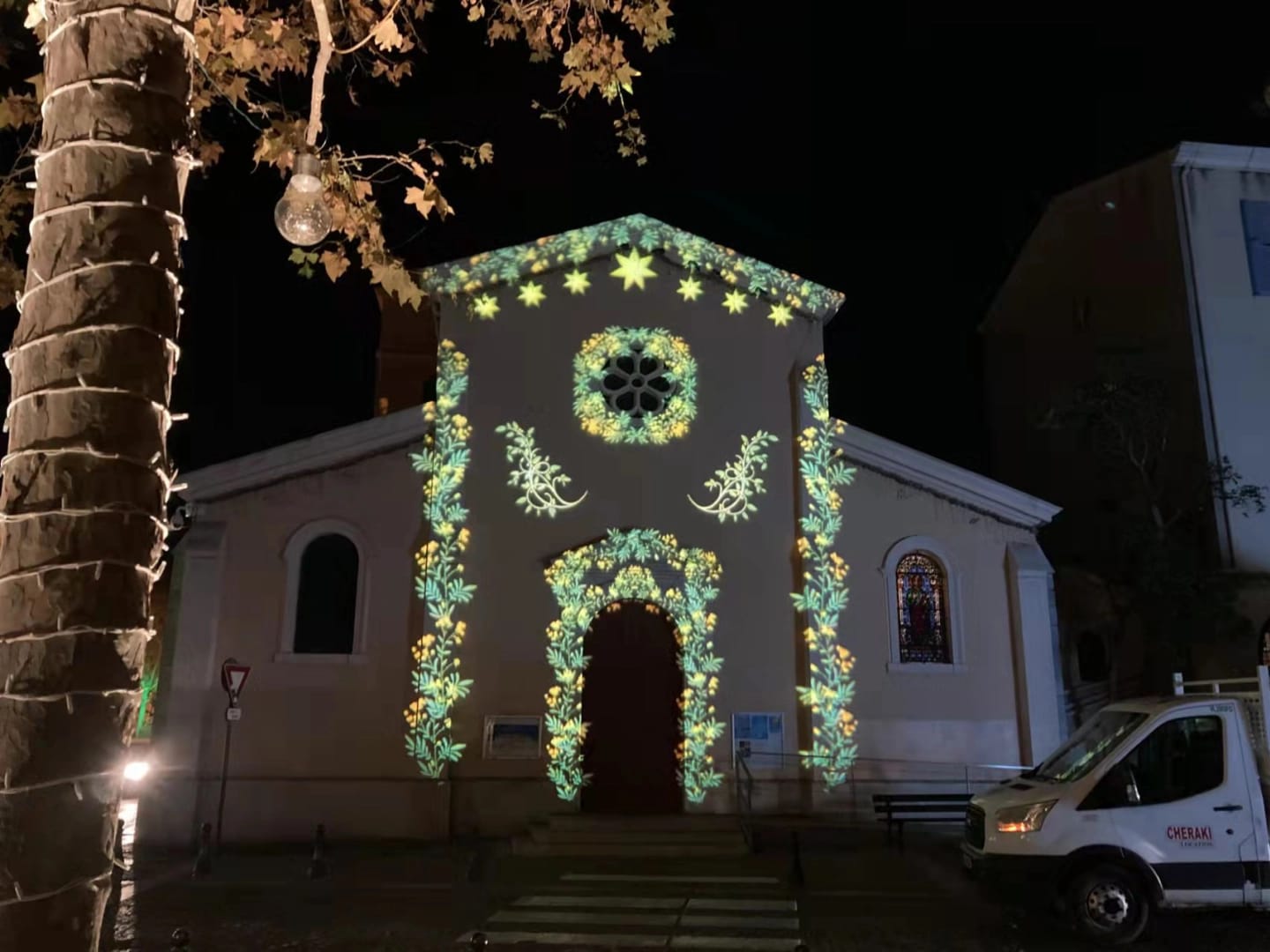 Floral gobo garlands framing a chapel doorway and gable at night — Infinity Projectors