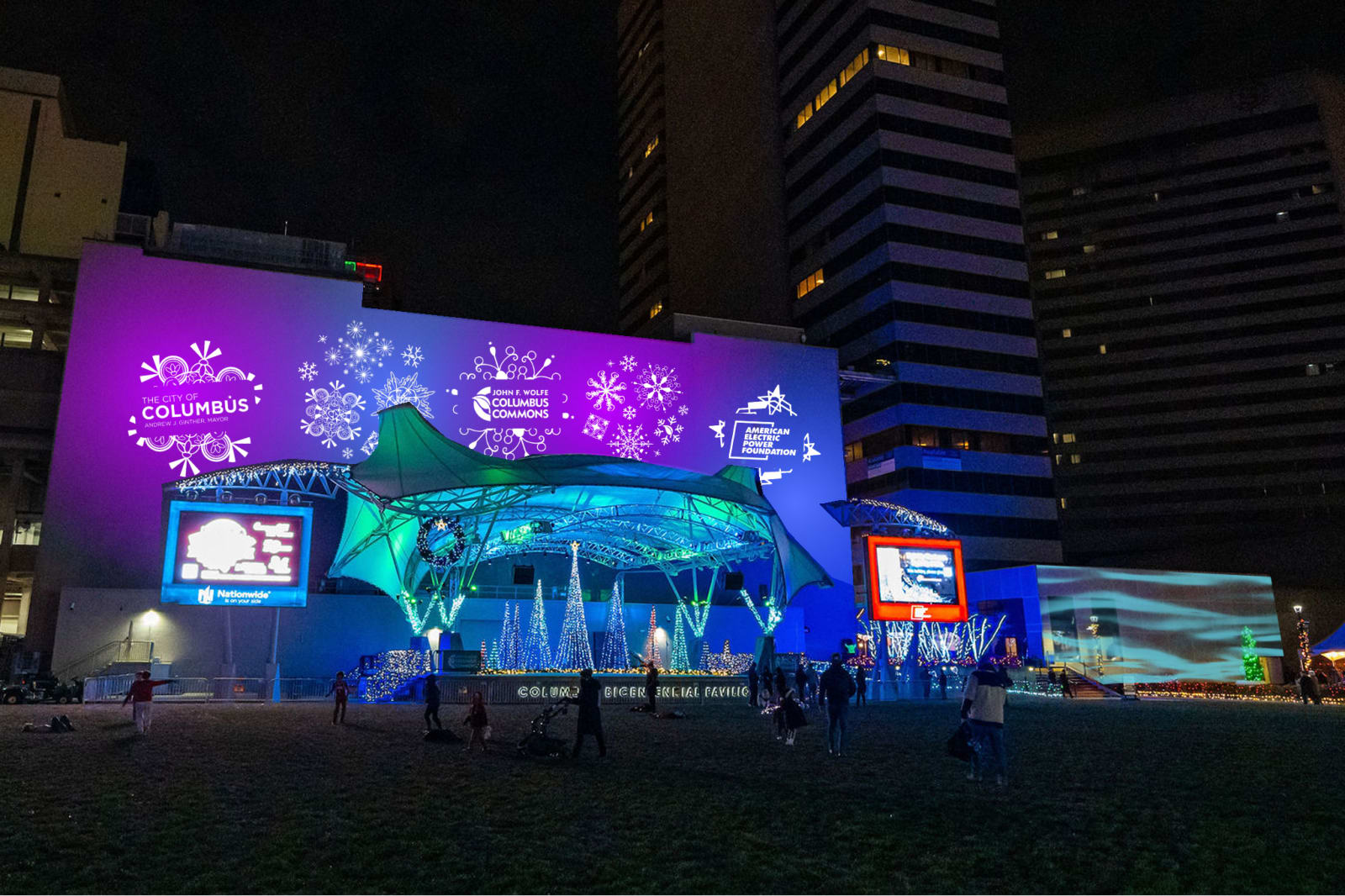 Mockup of holiday snowflake and sponsor logo projections covering a downtown pavilion wall above Christmas trees