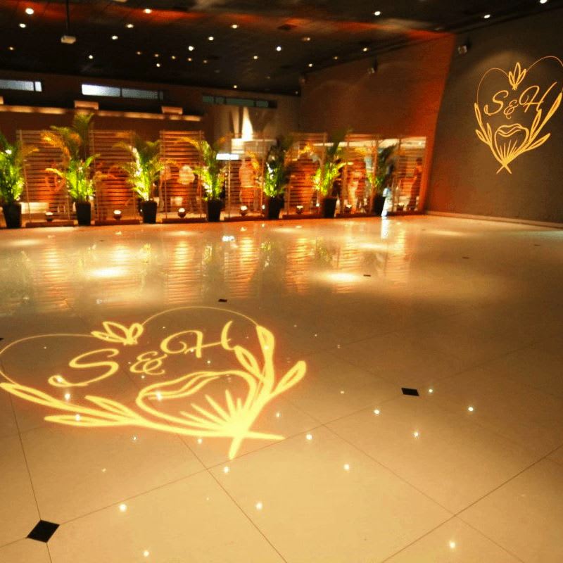 real photo of golden text/floral design projected on ballroom floor