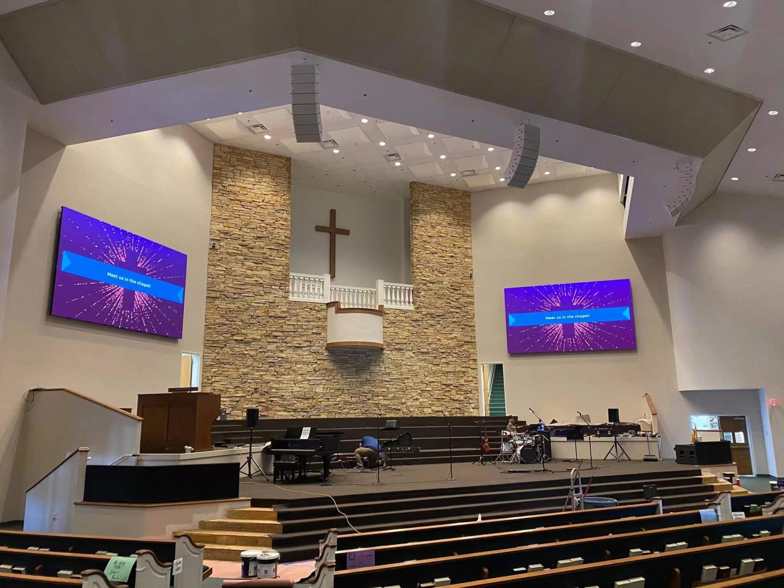 Twin LED video walls flanking a wooden cross in a church sanctuary — Infinity Projectors