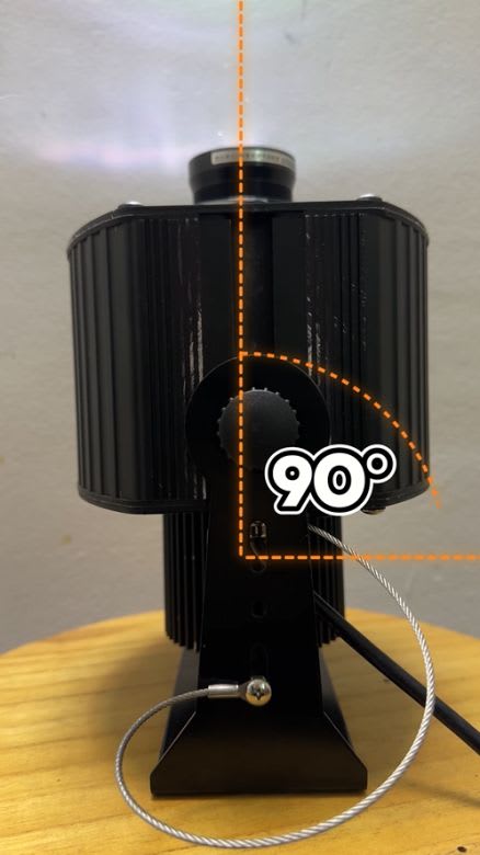 Video: close-up of a black gobo projector tilted 90 degrees on its bracket with a safety cable attached