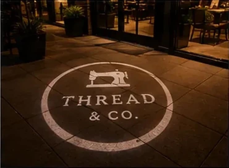 "Shop Local, Support Local" projection on a brick storefront — Infinity Projectors