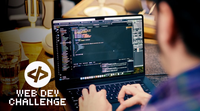 over the shoulder shot of a developer's laptop showing code on a warmly lit desk