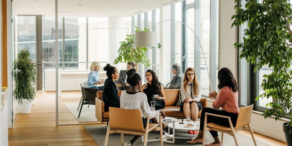 Professional men and women meet in collaborative workplace