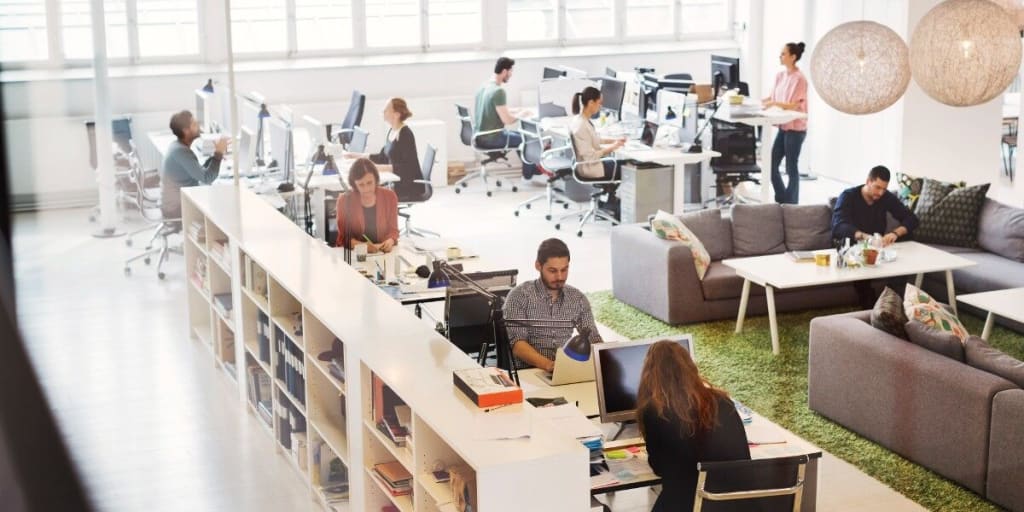 Business people work in bright open plan office space