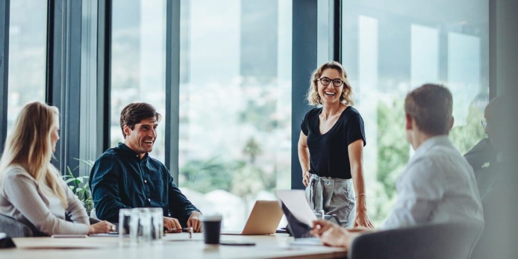 Business women and men meet around a conference room table to discuss metrics that matter