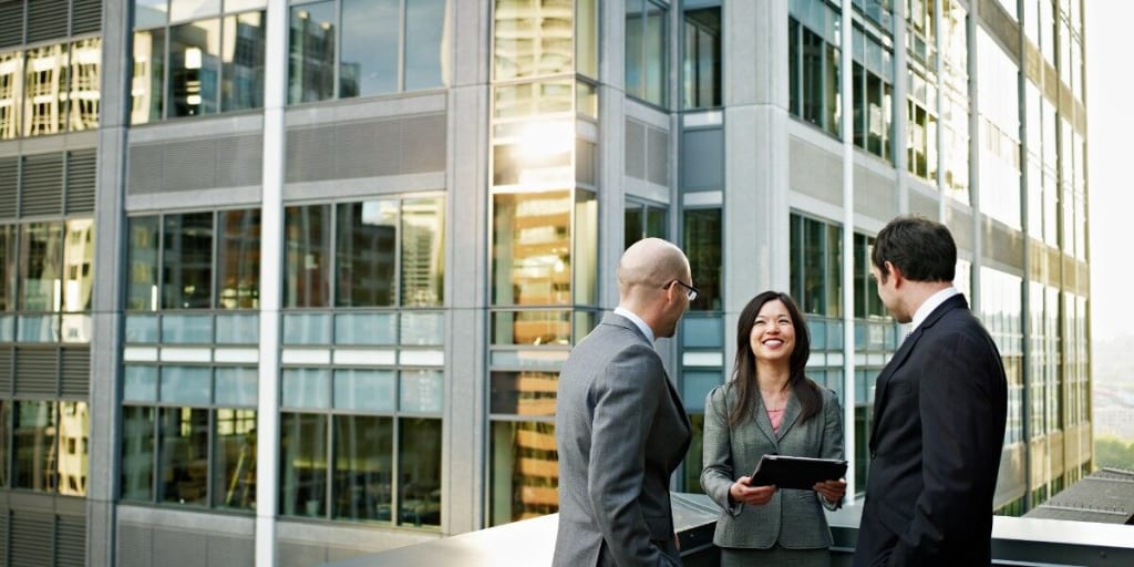 Business people meet on patio of office building