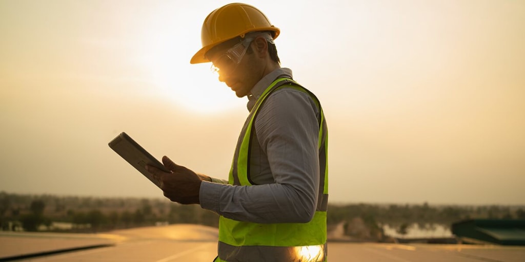 facilities manager with laptop on roof