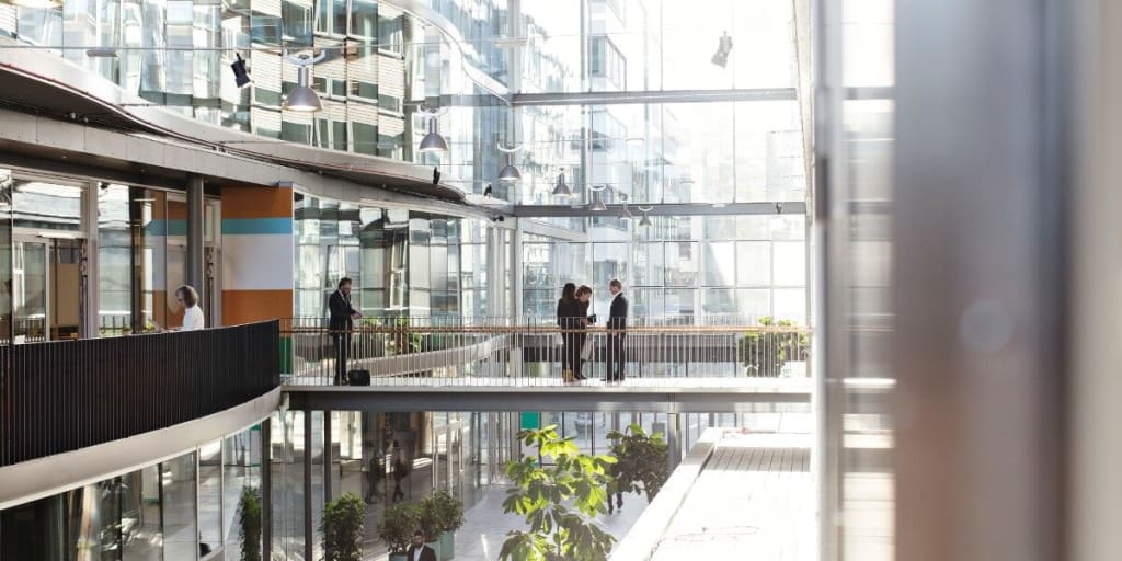 Business people congregate on various levels of glass building