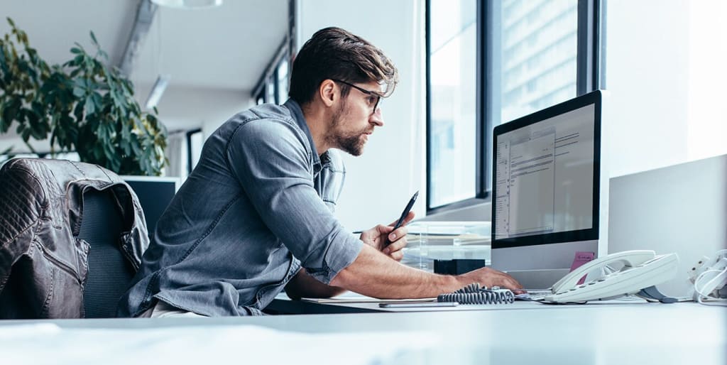 Facilities manager works at desktop computer