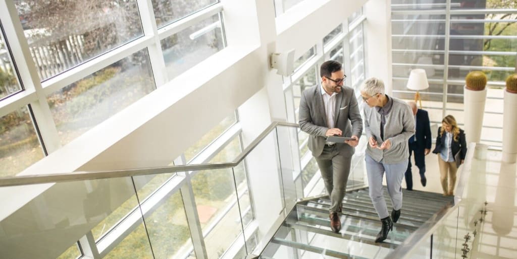 Business people walk up a set of stairs in office building