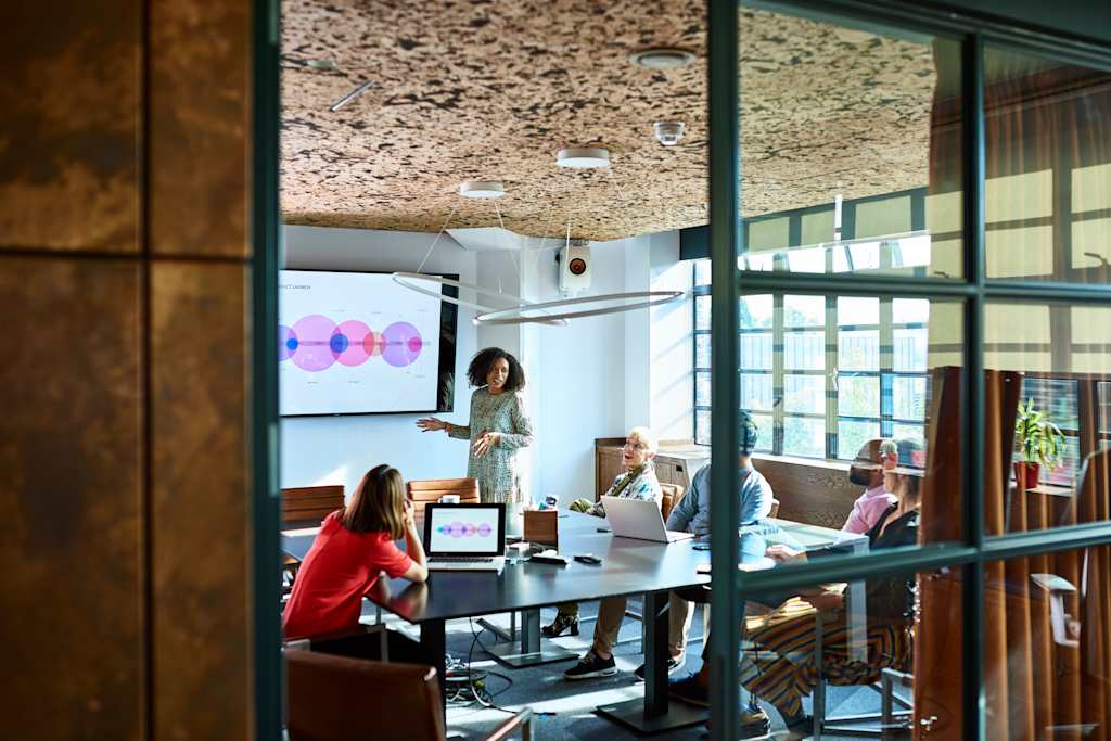 People in conference room discussing presentation on screen
