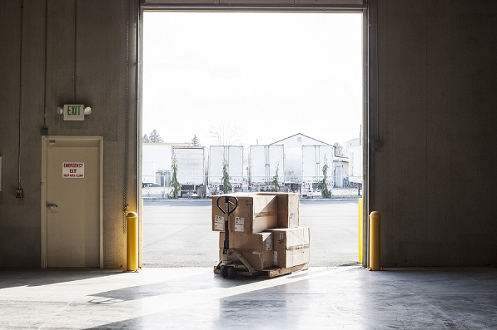 two-employees-checking-inventory-beside-racks-of-boxes-in-temporary-storage-in-a-distribution-warehouse two-employees-checking-inventory-beside-racks-of-boxes-in-temporary-storage-in-a-distribution-warehouse