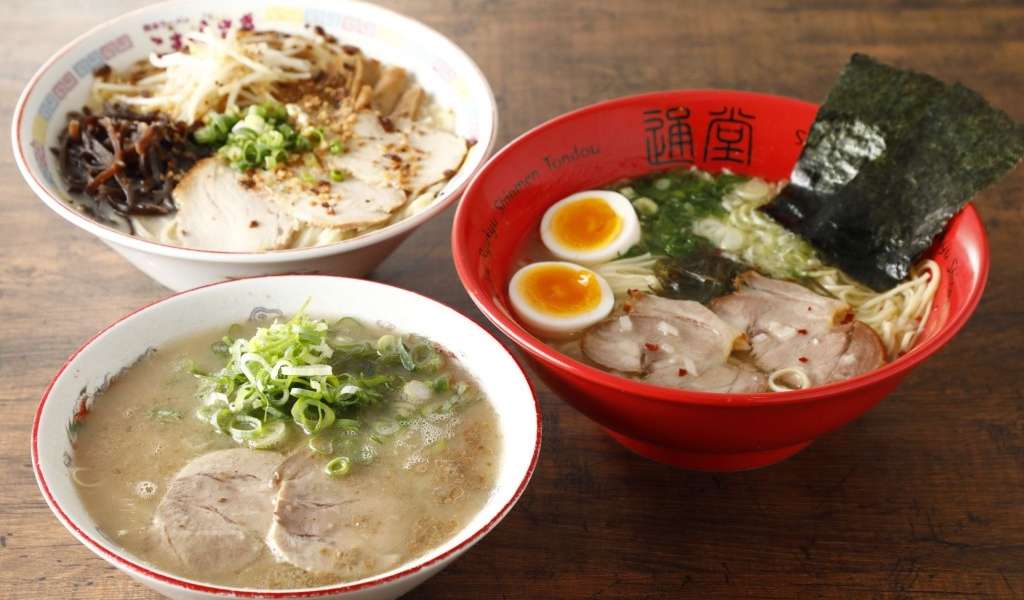 Three bowls with different types of ramen in them