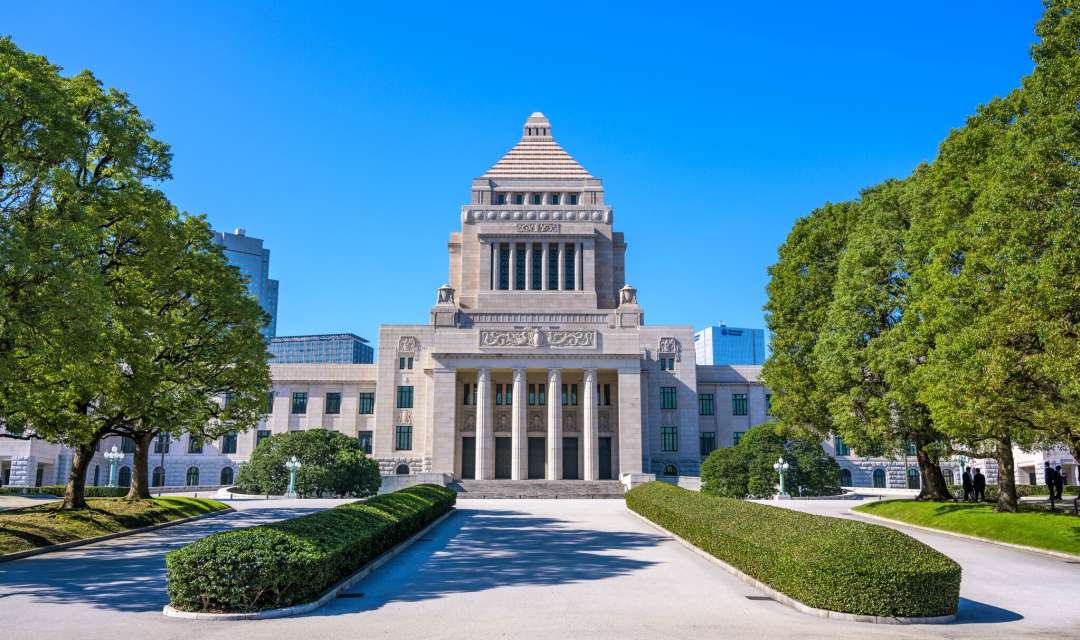 An official building with columns set in a manicured garden