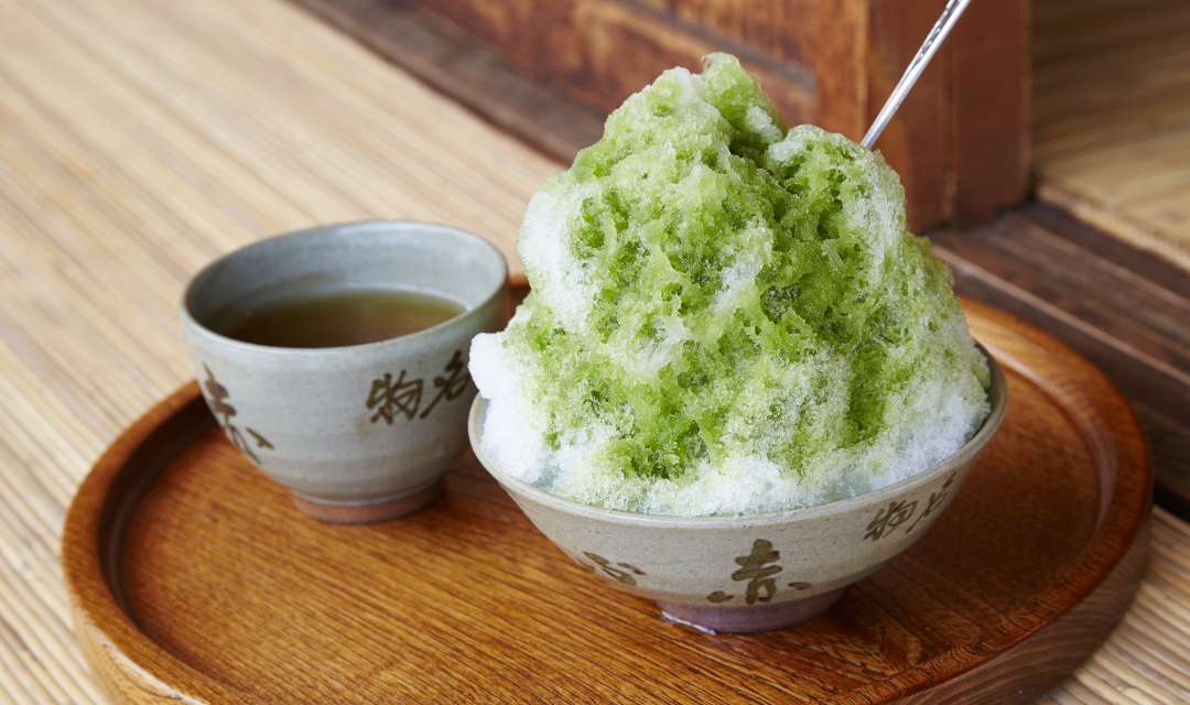 matcha-flavoured Kakigori iced dessert on a table with tea