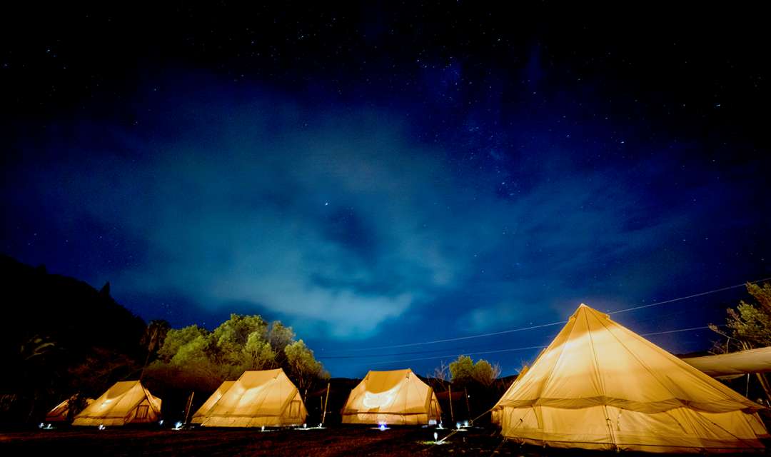 a row of tipis at night