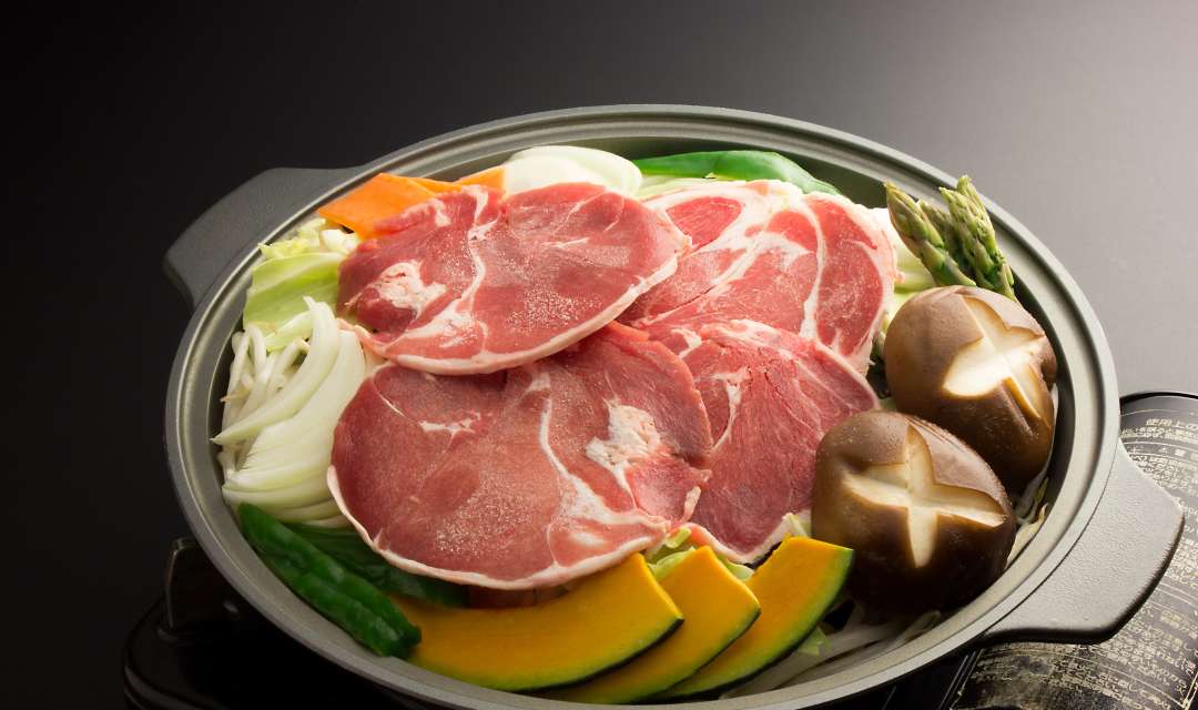 a pan full of raw meat and vegetables on a grey bancground