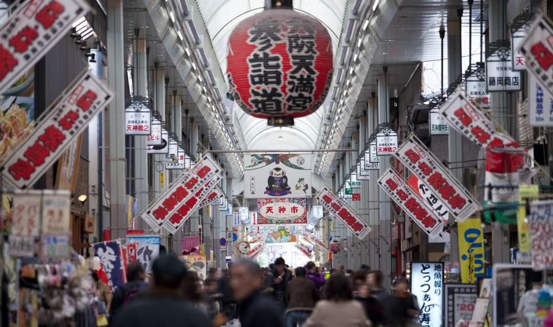 a shopping precinct with signs either side and a lantern hanging from the ceiling