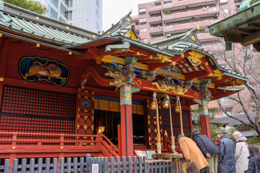 People with their heads bowed at Konno Hachimangu Shrine in Shibuya, Tokyo