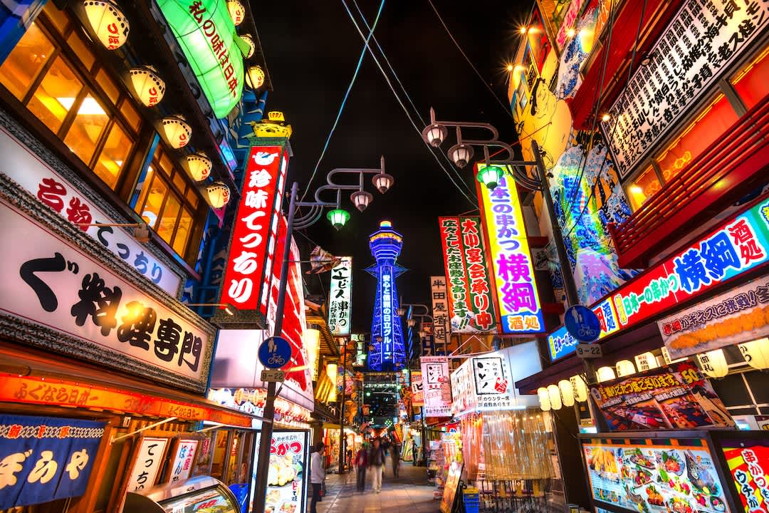 Tsutenkaku Tower lit up at night* in the Shinsekai (new world) district at night.