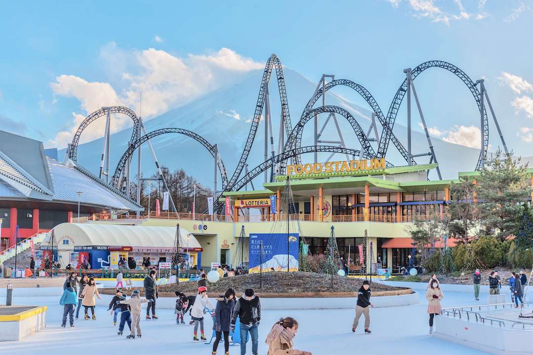 People ice skating at Fuji-Q Highland in front of the Fujiyama - King of Coasters rollercoaster.