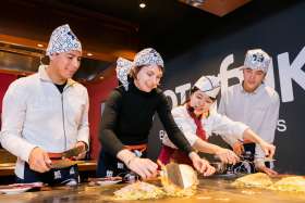 cooking your own Hiroshima-style okonomiyaki in OKOSTA Okonomiyaki Cooking Studio