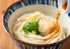 Bukkake udon noodles with toppings and sauce mixed up in a bowl
