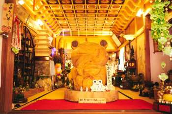 Large wooden frog statue at Nyoirinji Temple surrounded by various figurines at Nyoirinji Temple in Fukuoka Prefecture